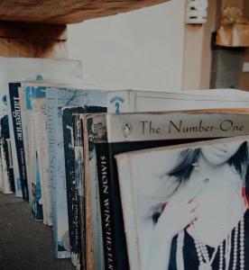 a row of books sitting on a shelf at Adi House Homestay in Ubud