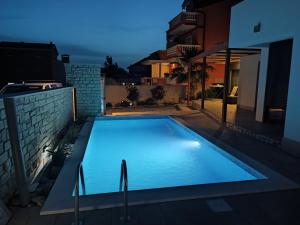 a swimming pool in the backyard of a house at night at Kuća za odmor MARIA in Vodice