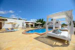 a patio with a bed and a swimming pool at Can Balafi in Cala Llonga