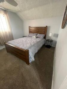 a bedroom with a bed with a wooden head board at Comfortable 2 Bedroom Home in Historic Hibbing in Hibbing