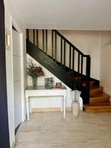 un couloir avec une table blanche et un escalier dans l'établissement Charmante Villa Quintel - Proche Gare & Centre, à Brive-la-Gaillarde