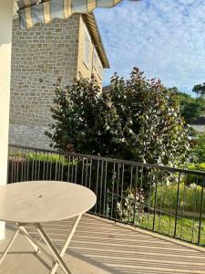 una terrazza in legno con tavolo e recinzione di Charmante Villa Quintel - Proche Gare & Centre a Brive-la-Gaillarde