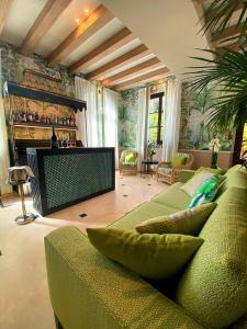 a living room with a green couch and a fireplace at Resort Al Forte in Forte dei Marmi