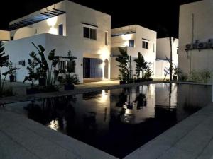 a night view of a house with a swimming pool at Skytel Palawan in Puerto Princesa City