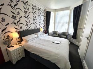 a hotel room with a bed and two chairs at Bella Vista Lodge in Blackpool