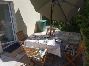 a table and chairs with an umbrella on a patio at Ferien am Bergpark - Kassel, Bad Wilhelmshöhe in Kassel +26 photos