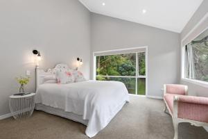 a white bedroom with a bed and a window at Seaside Serenity - Kerikeri Holiday Home in Kerikeri
