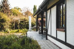 un porche de una casa con mesa y bancos en Guesthouse Ter Linden en Bazel