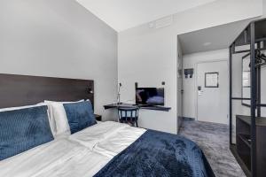 a bedroom with a bed and a television in it at Thon Partner Hotel Horten in Horten