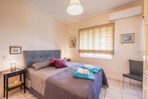 een slaapkamer met een bed, een bureau en een stoel bij Glyfada's Cosy Apartments in Athene