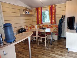 a small room with a table and a kitchen with a tableablish at Camping le ried B021 et N038 in Boofzheim