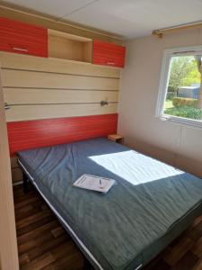 a small room with a bed with a window at Camping le ried in Boofzheim