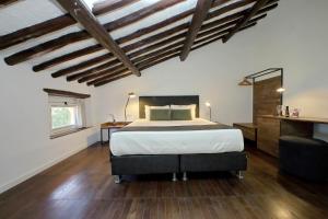 een slaapkamer met een groot bed met houten vloeren en houten plafonds bij Youroom Corsini in Rome