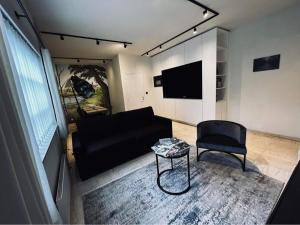 Bazel的住宿－Guesthouse Ter Linden，客厅配有黑色沙发和椅子