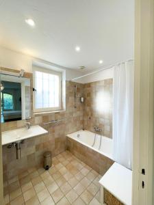 La salle de bains est pourvue d'une baignoire et d'un lavabo. dans l'établissement Studio 8 - LES SUITES DE ROBINSON - Résidence avec piscine en bord de Siagne, à Mandelieu-La-Napoule, à Mandelieu-la-Napoule