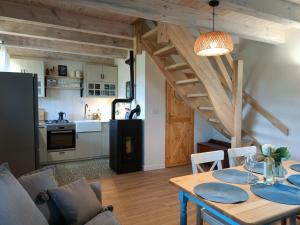 a kitchen and a dining room with a table with blue plates at Smocze Ranczo 2 in Ośno Lubuskie