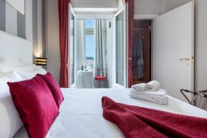 een slaapkamer met een groot wit bed met rode kussens bij Bed And Breakfast Del Fiore in Cagliari