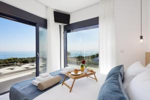 a living room with a blue couch and large windows at Villa Empire with Magical sea view in Chania