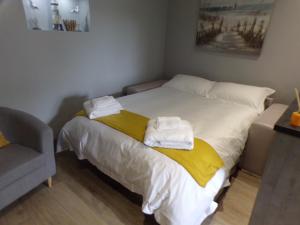 1 dormitorio con 1 cama con toallas en 4TheDome- Deluxe ground floor apartment opposite the sea, en Barton-on-Sea