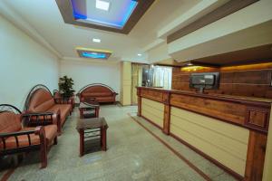 uma sala de espera com cadeiras e uma televisão em Hotel oneiro em Thrissur