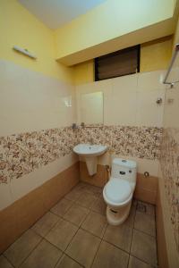 een badkamer met een toilet en een wastafel bij Hotel oneiro in Trichūr