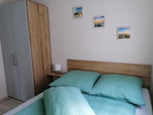 a bedroom with a bed with two green pillows at Ferienhaus Leo in Blankenrath
