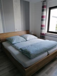 een bed met een houten frame in een slaapkamer bij Ferienhaus Leo in Blankenrath