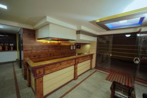 a kitchen with a wooden counter top in a room at Hotel oneiro in Trichūr