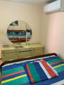 a bedroom with a bed with a dresser and a mirror at Florians Guesthouse in Shkodër