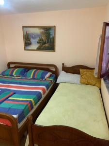 a bedroom with two beds and a painting on the wall at Florians Guesthouse in Shkodër