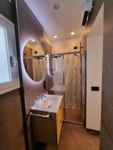 a bathroom with a sink and a shower with a mirror at Archihouse Suites in Naples
