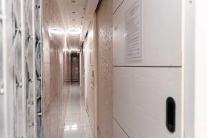 um corredor com paredes de madeira e um longo corredor com um frigorífico em Patent Guest House Syariah RedPartner em Palimbão