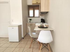 a small kitchen with a table and two white chairs at # 6 Giorgos & Chara apartments in Nea Kydonia