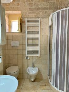 een badkamer met een toilet, een wastafel en een douche bij TENUTA MONTANARO in Locorotondo