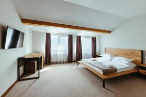 una grande camera da letto con letto e scrivania di HUSTON a Chust