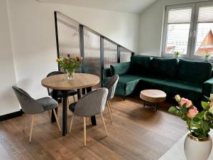 a living room with a couch and a table and chairs at Apartamenty Śleboda in Czarny Dunajec