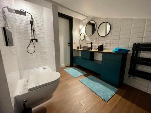 a bathroom with a toilet and a sink and mirrors at Apartamenty Śleboda in Czarny Dunajec