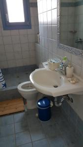 uma casa de banho com um lavatório e um WC em Villa Mariza em Loutrá