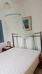a bedroom with a white bed with a canopy at Villa Mariza Kythnos in Kithnos