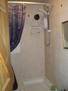 a bathroom with a shower with a tub and a shower head at Fisher-gill Camping Barn in Thirlmere