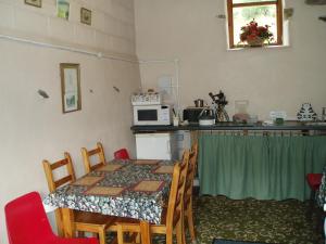 a room with a table and a kitchen with a microwave at Fisher-gill Camping Barn in Thirlmere