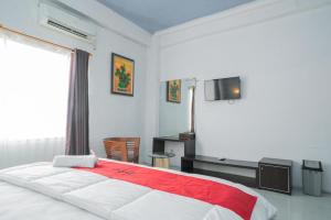 a bedroom with a large bed and a television at RedDoorz @ Kampung Sawah Jatimurni Bekasi in Kampungsawah Dua