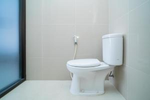 a bathroom with a white toilet in a room at RedDoorz @ Kampung Sawah Jatimurni Bekasi in Kampungsawah Dua +33 photos