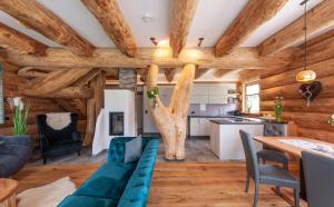 a kitchen and living room with wooden ceilings and a blue couch at Das Blockhaus Gosau in Gosau