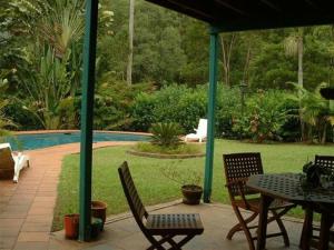 a patio with a table and chairs and a pool at Riviera Bed & Breakfast in Gold Coast