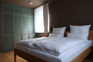 a bedroom with a large white bed with a window at Gerono - Haus am See in Wusterwitz