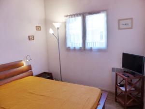 um quarto com uma cama, uma televisão e uma janela em Appartement Avec Piscine En Copropriete Pour 6 Personnes- Residence Notre-Dame Du Port em Capbreton