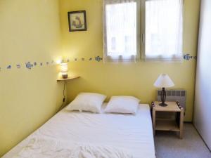 um pequeno quarto com uma cama e uma janela em Appartement Avec Piscine En Copropriete Pour 6 Personnes- Residence Notre-Dame Du Port em Capbreton