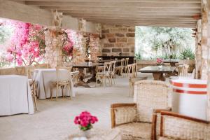 un ristorante con tavoli, sedie e fiori rosa di Masseria Torrepietra a Monopoli