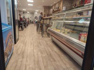 a store aisle with people sitting at tables in a bakery at Hotel ANDINO in Encamp